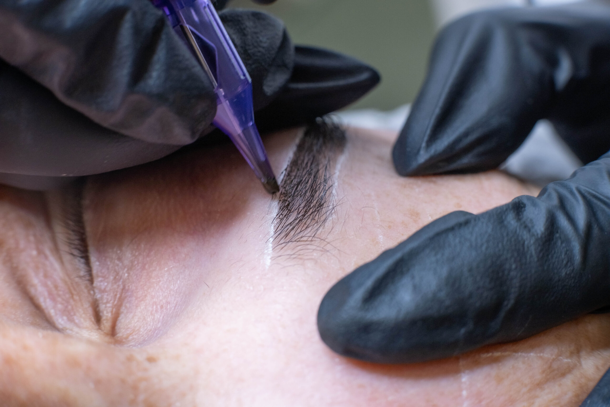 close-up reveals the precision of the microblading needle, delicately crafting each hair stroke. Witness the transformation of sparse brows into fuller. microblading or eyebrow tattooing